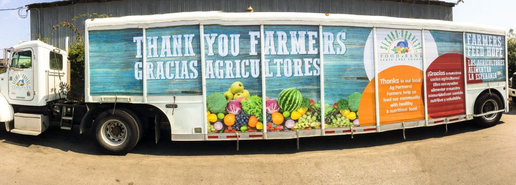 Camión de reparto antiguo con cartelería gráfica de agradecimiento a los agricultores